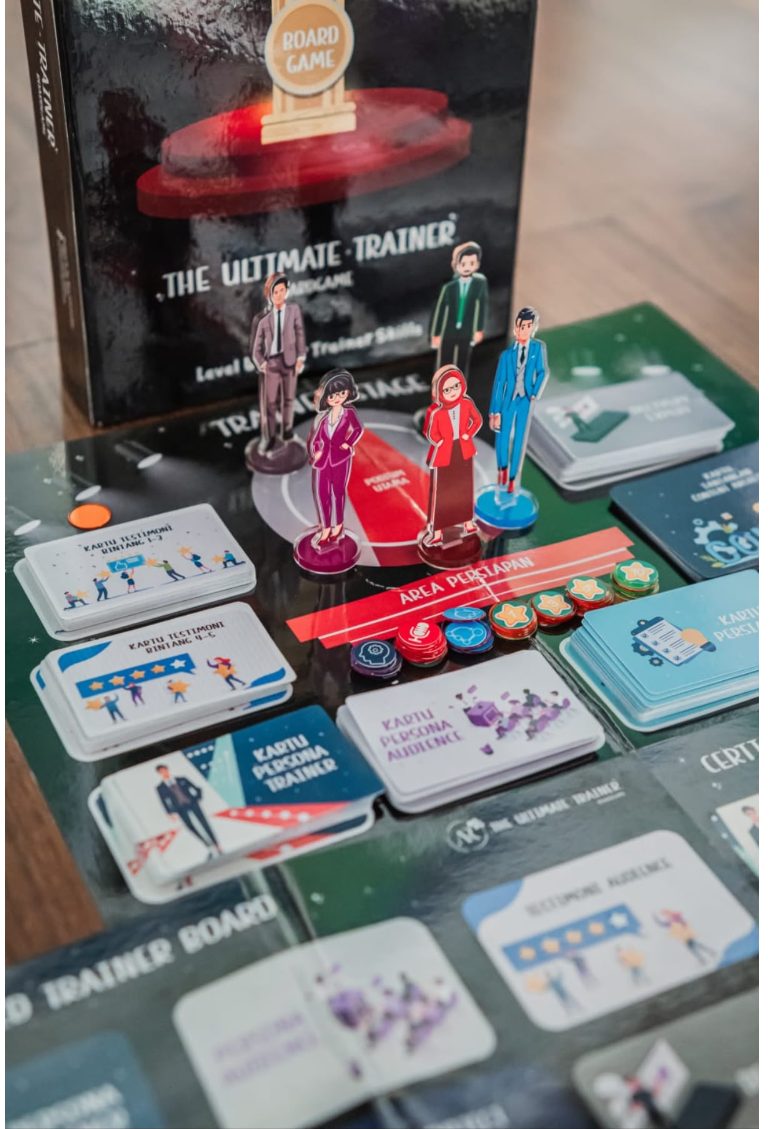 The Ultimate Trainer Board Game: kotak permainan, papan Trainer Stage, bidak karakter trainer, token, serta kartu persona trainer, persona audience, dan testimoni